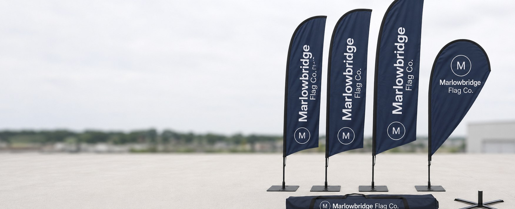 Custom printed feather flags, teardrop flags and pole kits on a concrete forecourt